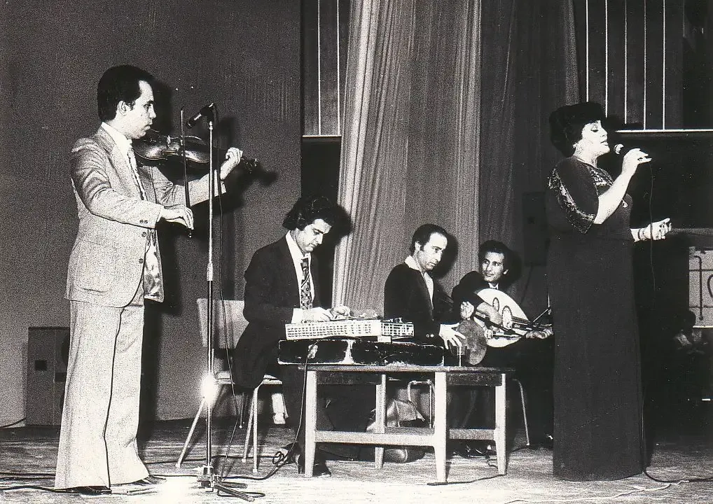 Hayedeh, Loghman Adhami, and other musicians at a concert, in the 1970s | هایده، لقمان ادهمی و دیگر نوازندگان در یک کنسرت، در دهه ۱۹۷۰ میلادی
